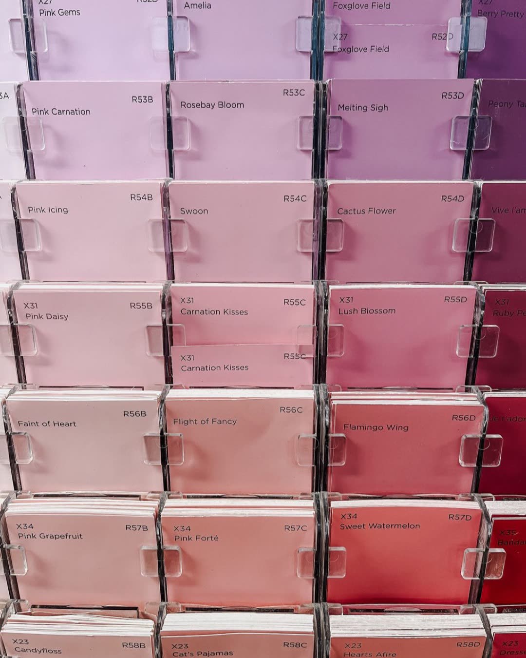 A vertical shot of pink-themed paint sample cards arranged in a grid pattern.