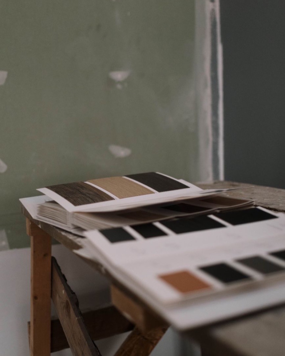 Close-up of interior renovation palette samples on a workbench, showcasing various color options.