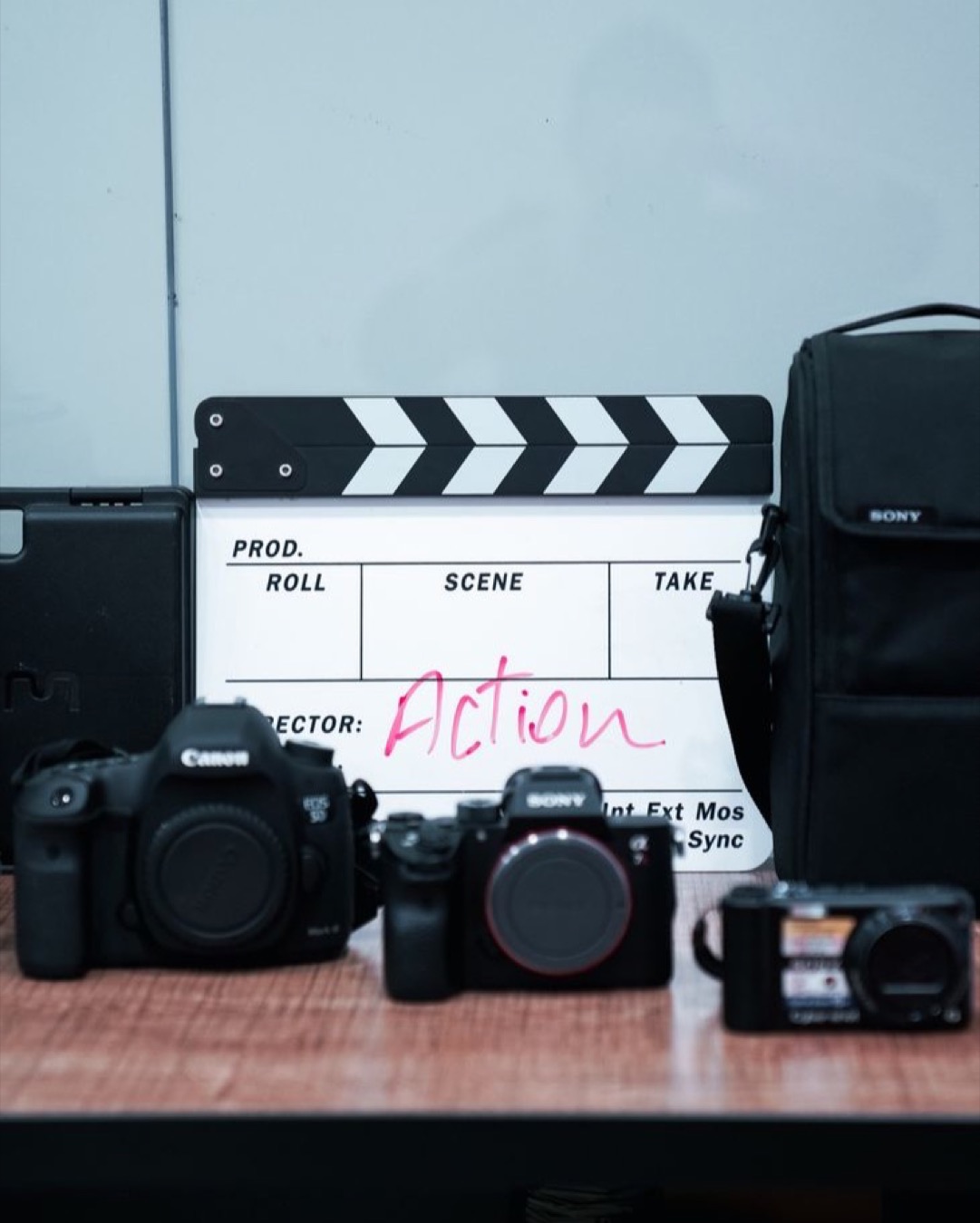 Clapperboard and cameras arranged on a desk, ideal for film production themes.