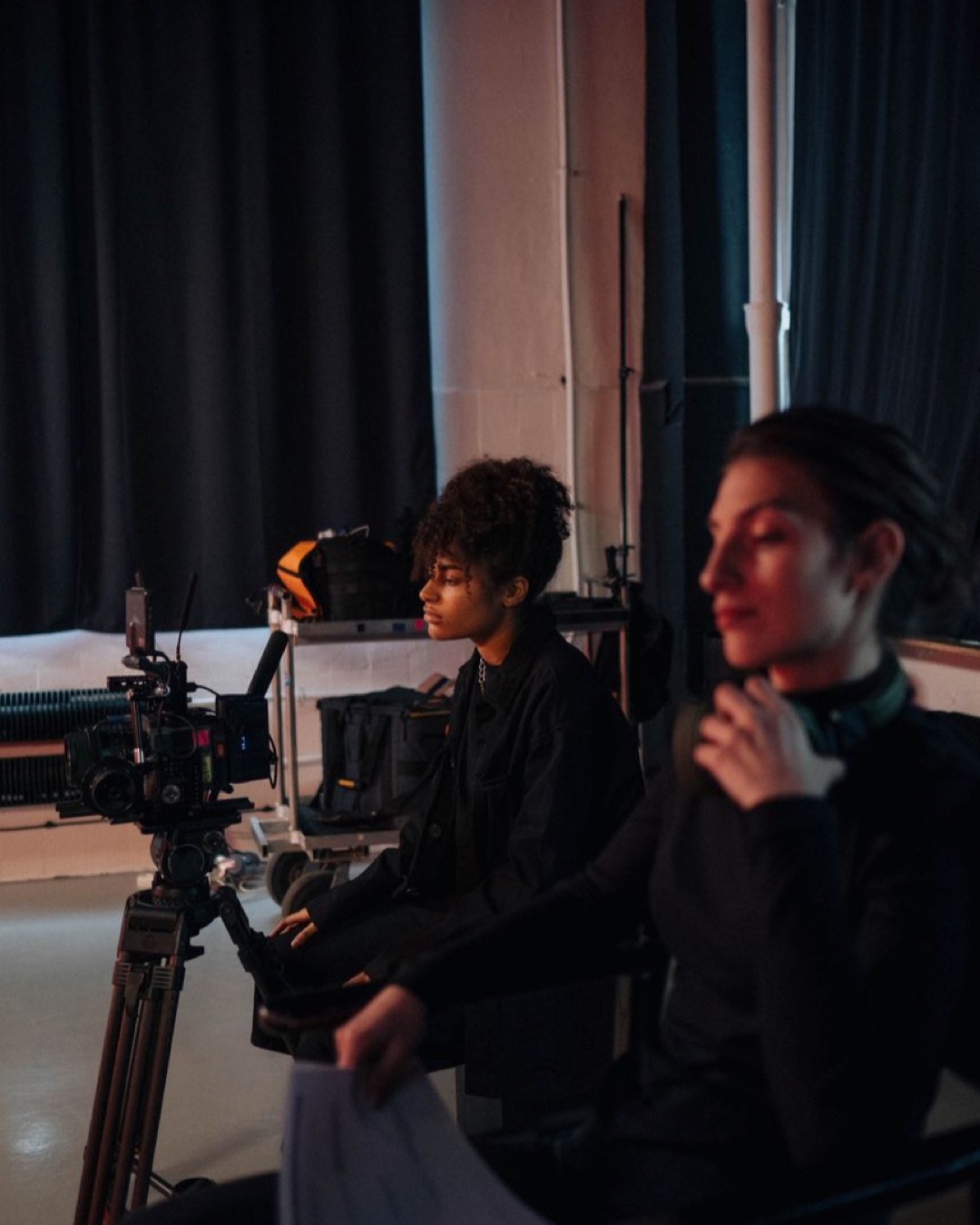 Camera crew working on an indoor set, featuring a videographer with equipment.