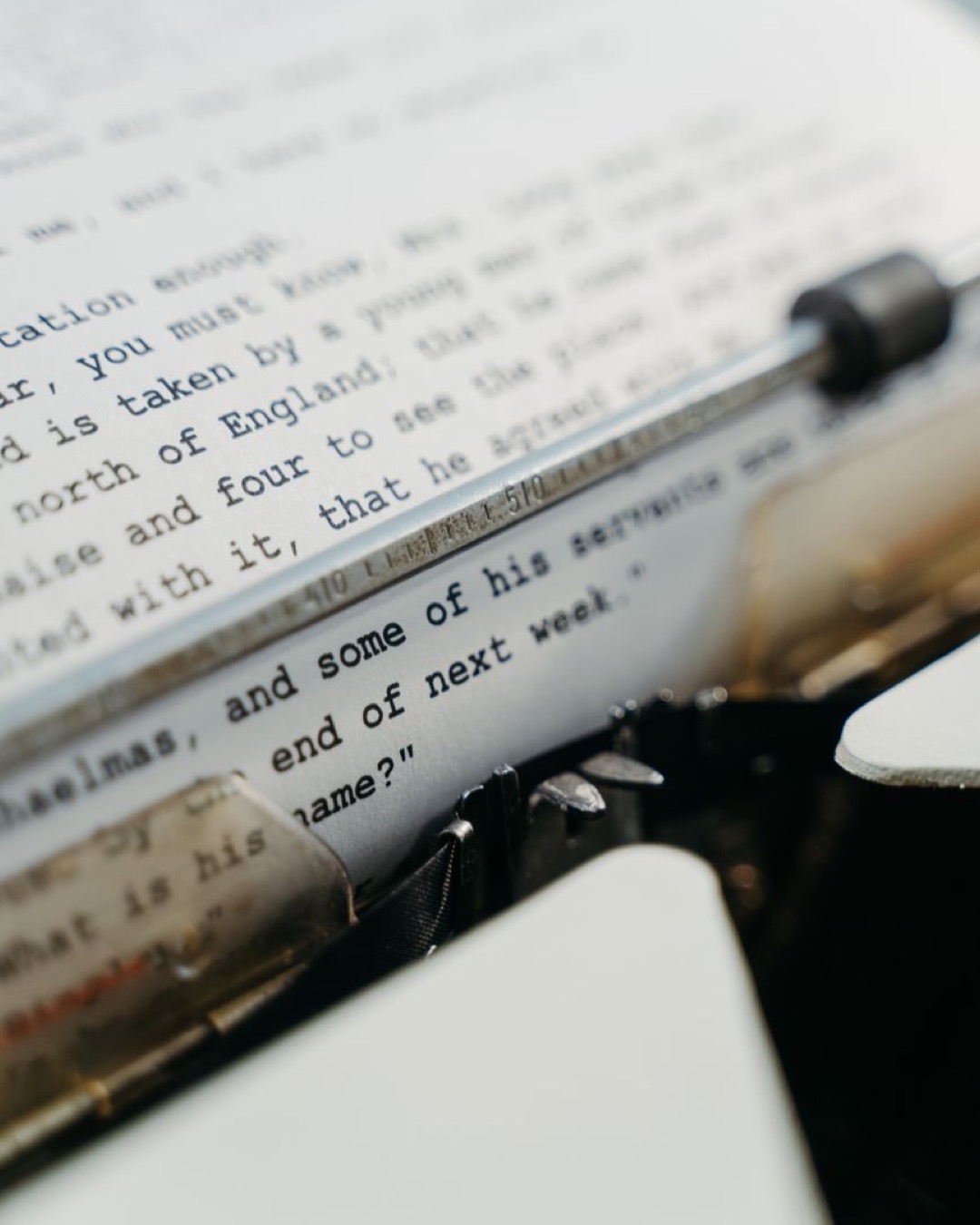 Detailed image of a typewriter with focus on typed text on paper, showcasing vintage technology.