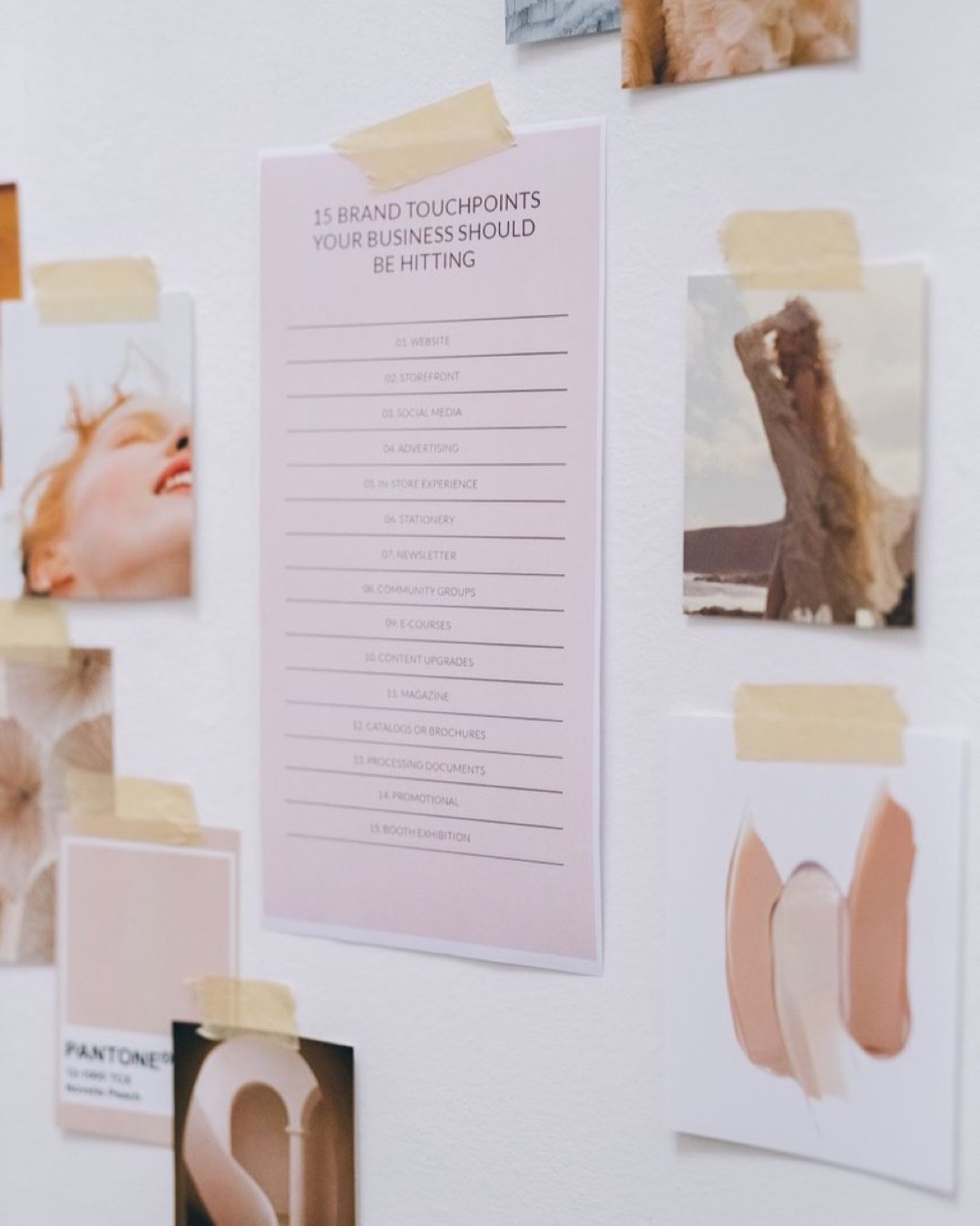 A creative mood board with business touchpoints and inspirational images taped to a white wall.
