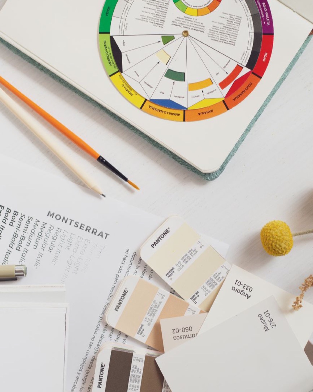 Top view of a creative workspace featuring color swatches, pencils, and design materials, ideal for branding projects.