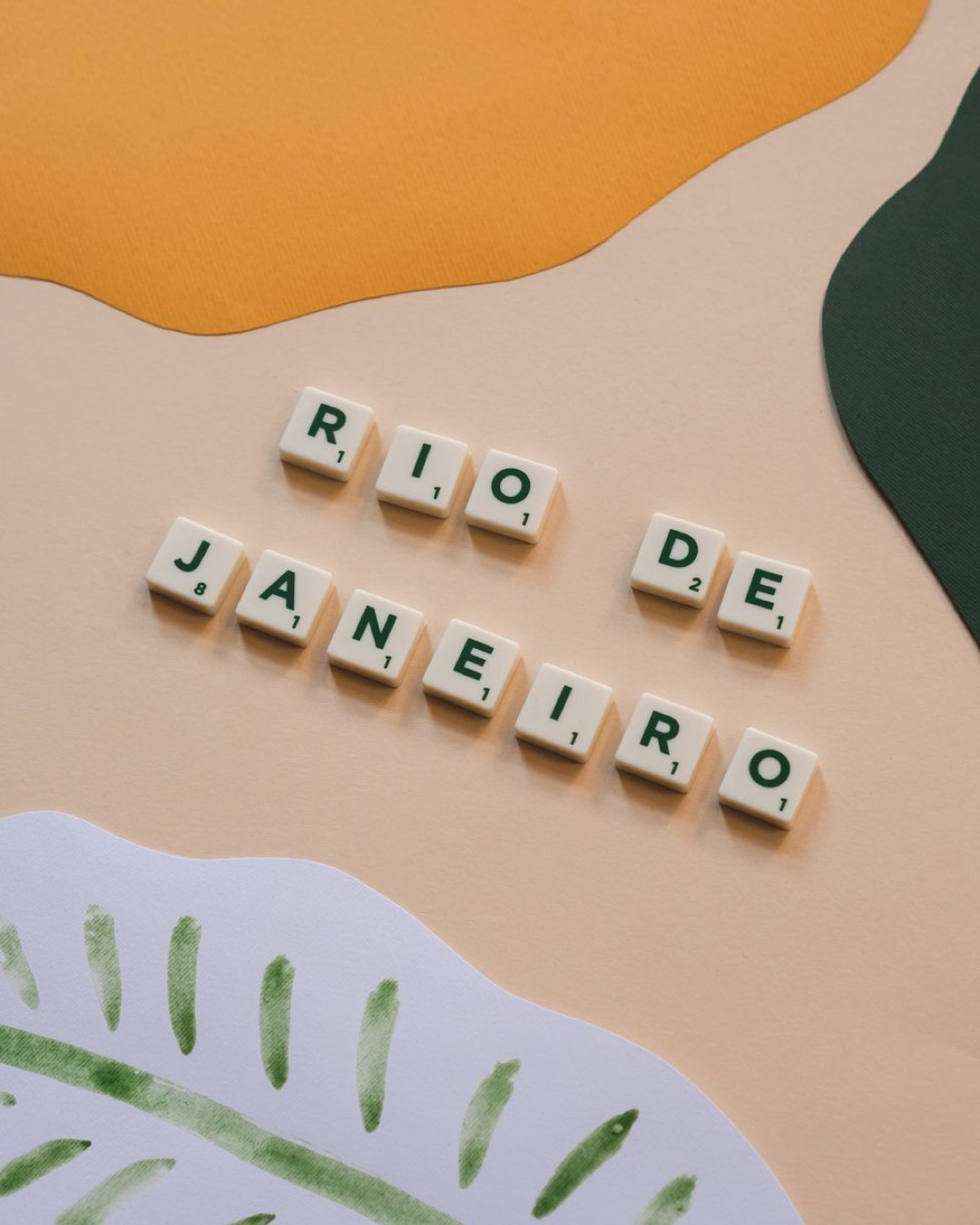 Creative arrangement of Scrabble tiles spelling 'Rio de Janeiro' on a vibrant abstract background.