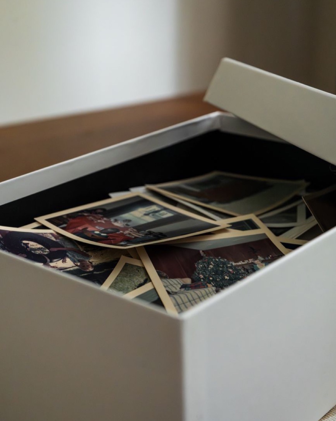 A nostalgic collection of vintage family photos in an open shoebox, evoking memories.