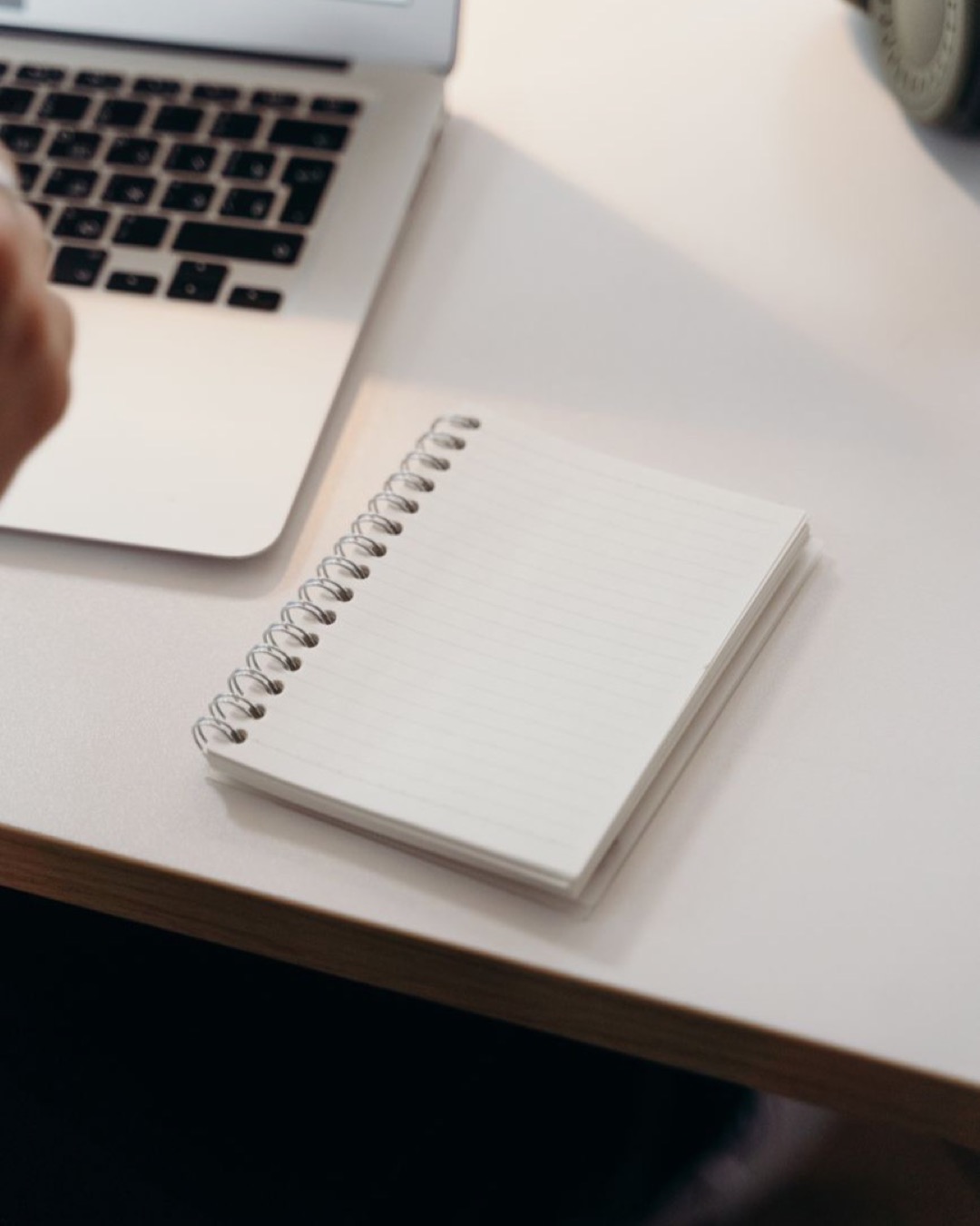 A clean workspace featuring a laptop and a spiral notebook on a desk, perfect for productivity.