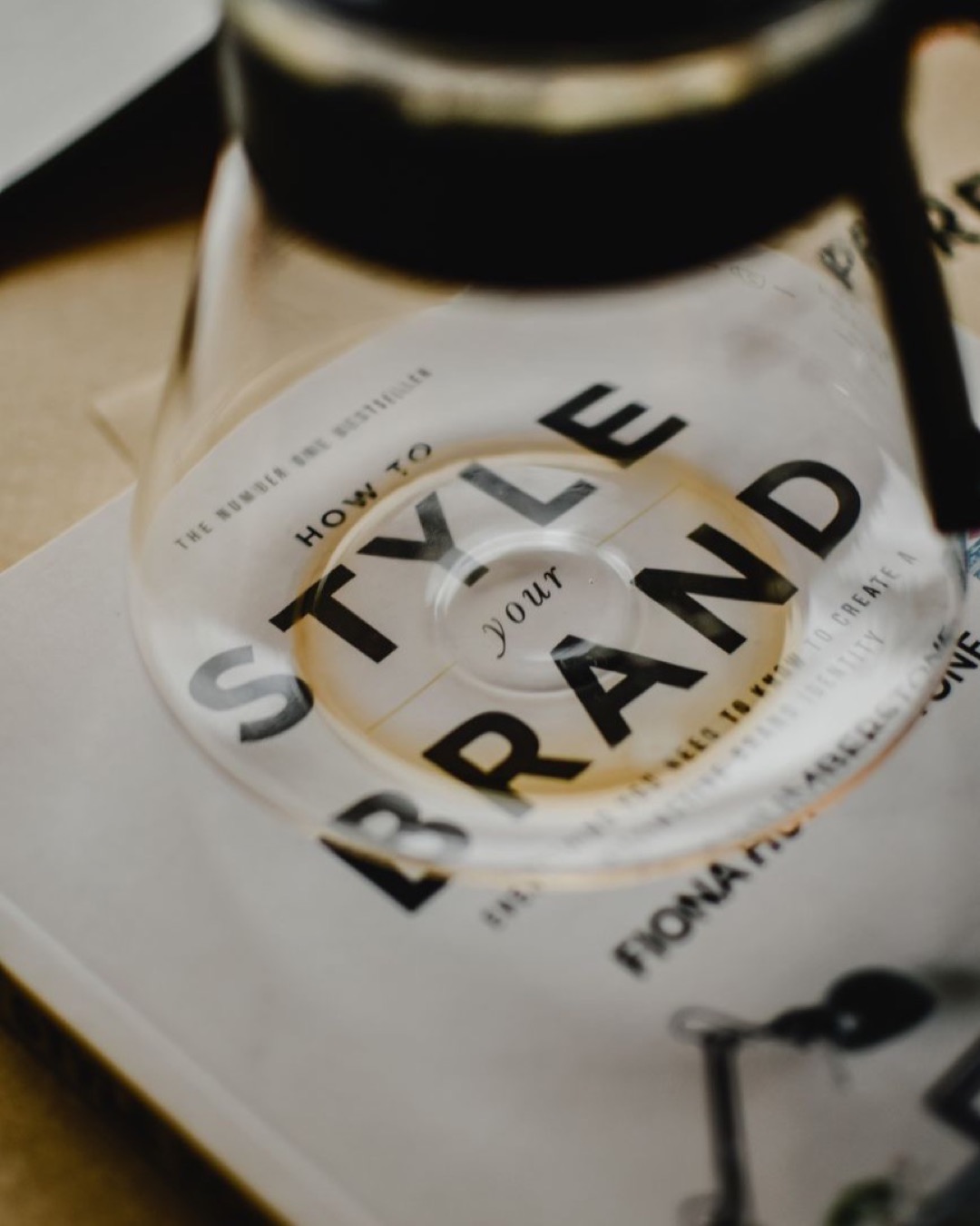 A coffee pot rests atop a book titled 'How to Style Your Brand', capturing the essence of creative branding.
