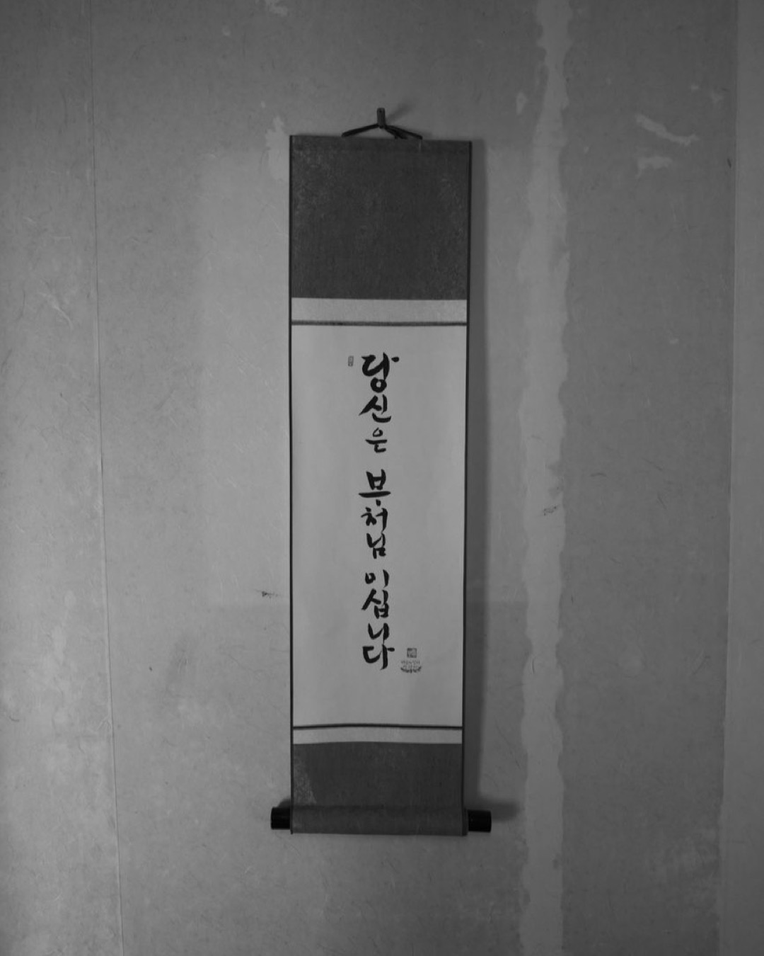 Elegant wall scroll featuring Korean script in black and white.