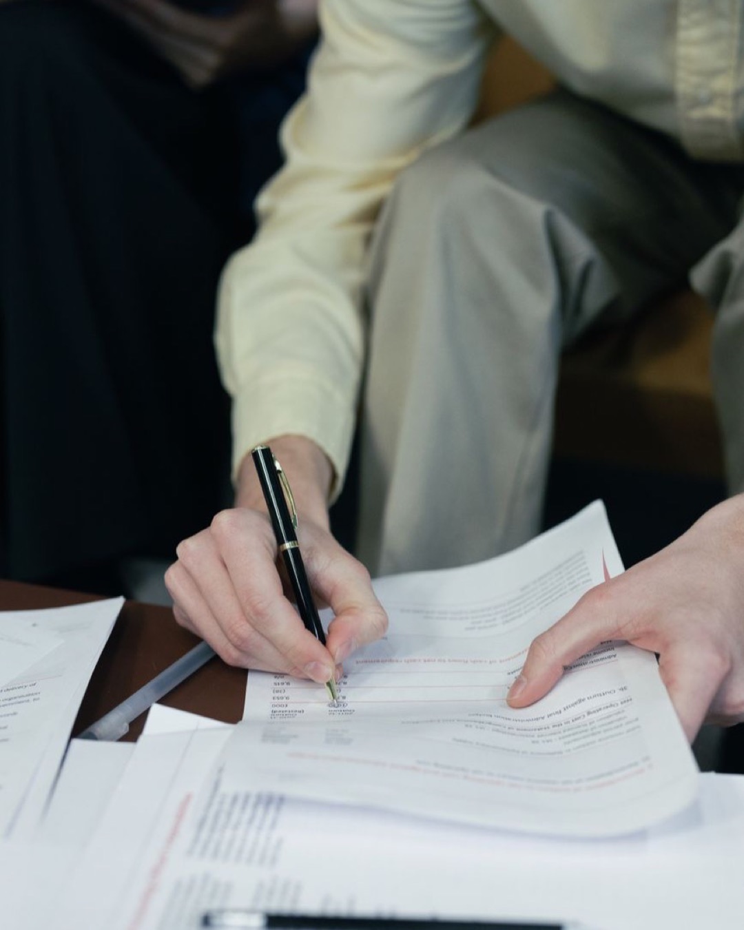 A focused close-up of a person signing essential paperwork, capturing the essence of business and documentation.