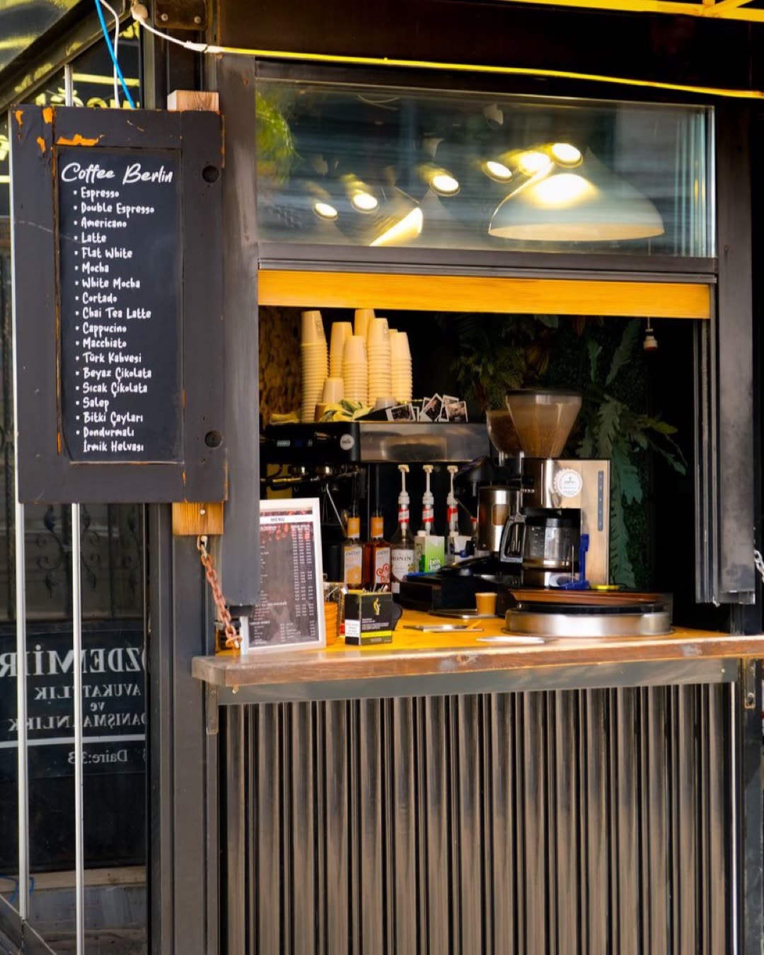 Small coffee bar kiosk with menu displaying espresso options and cozy atmosphere.