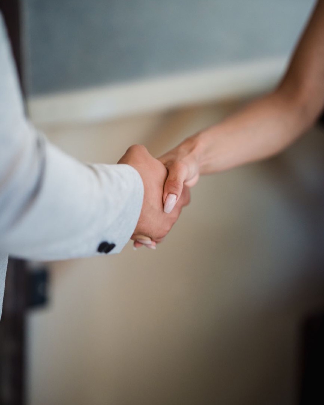 A close-up view of a handshake between two professionals, symbolizing agreement and partnership.