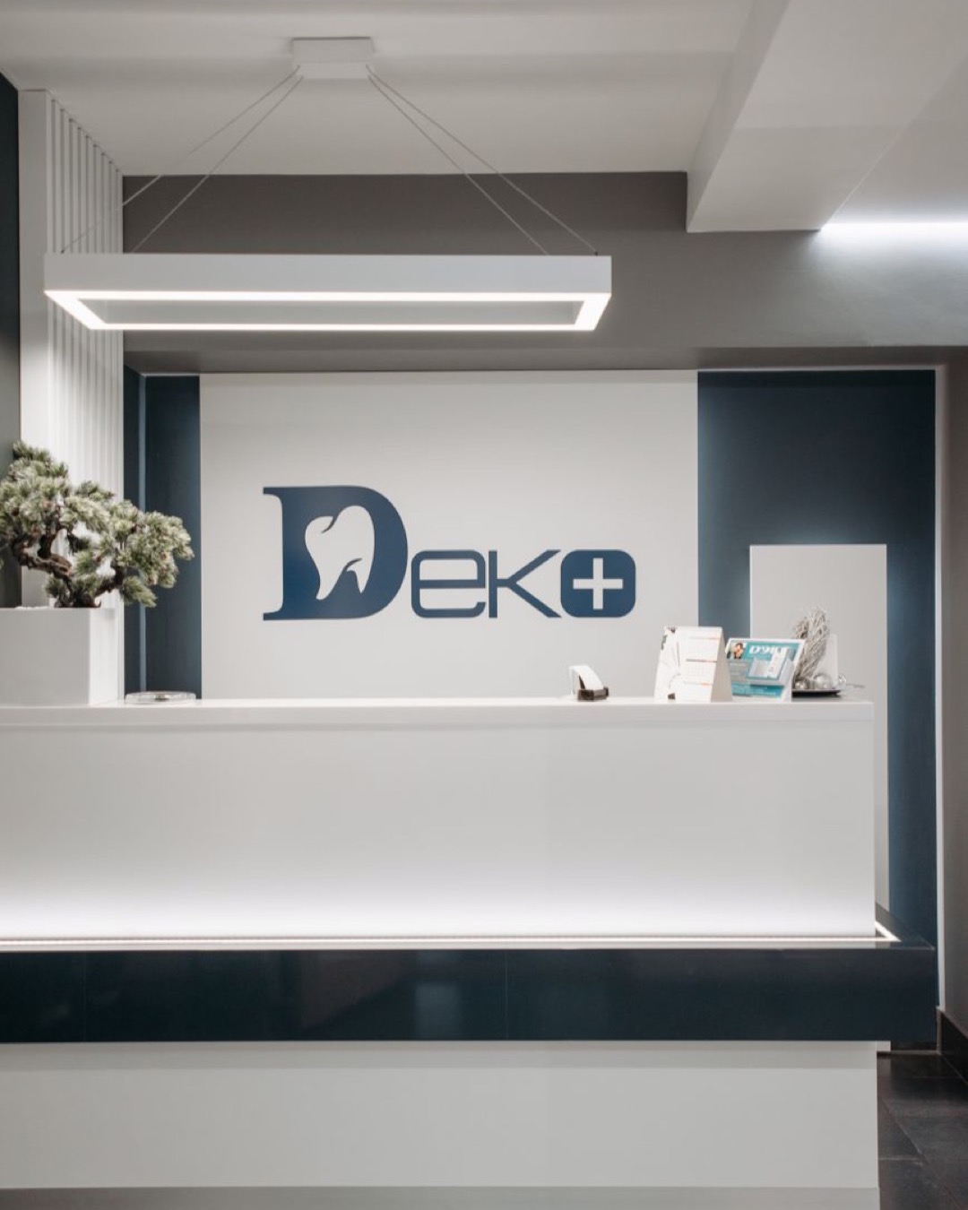 Clean and modern dental clinic reception area with minimalist design and stylish lighting.