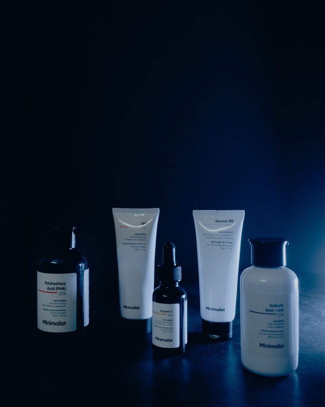 Elegant display of minimalist skincare products in a dark, moody setting.