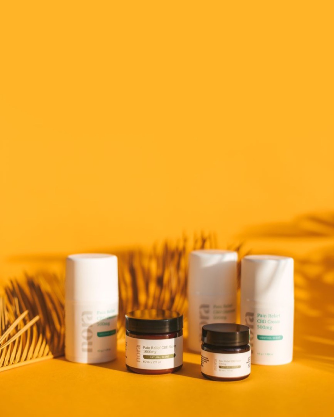Clean and minimalist skincare products displayed creatively on a vibrant yellow background with natural shadows.
