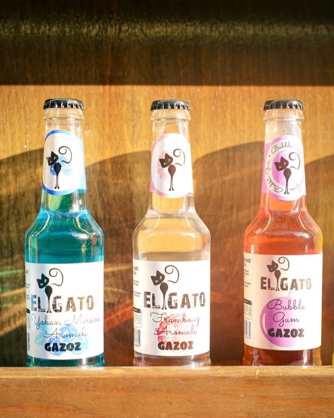 Three vibrant soda bottles arranged on a wooden shelf, perfect for beverage ads.