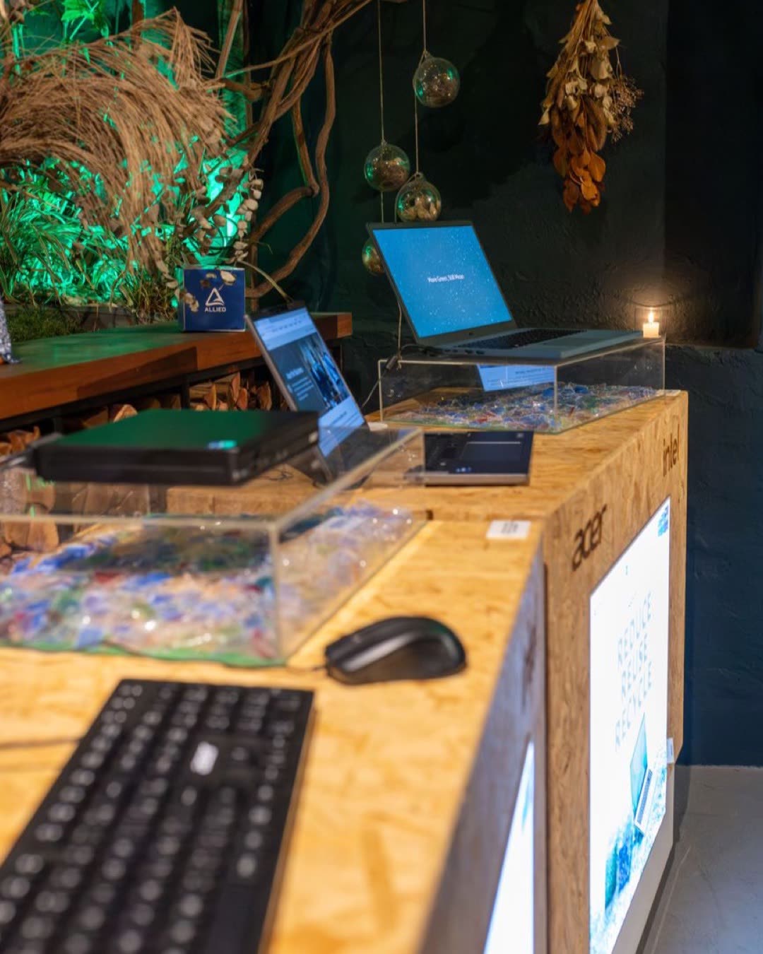 A modern technology setup with laptops and keyboards at an indoor exhibition.