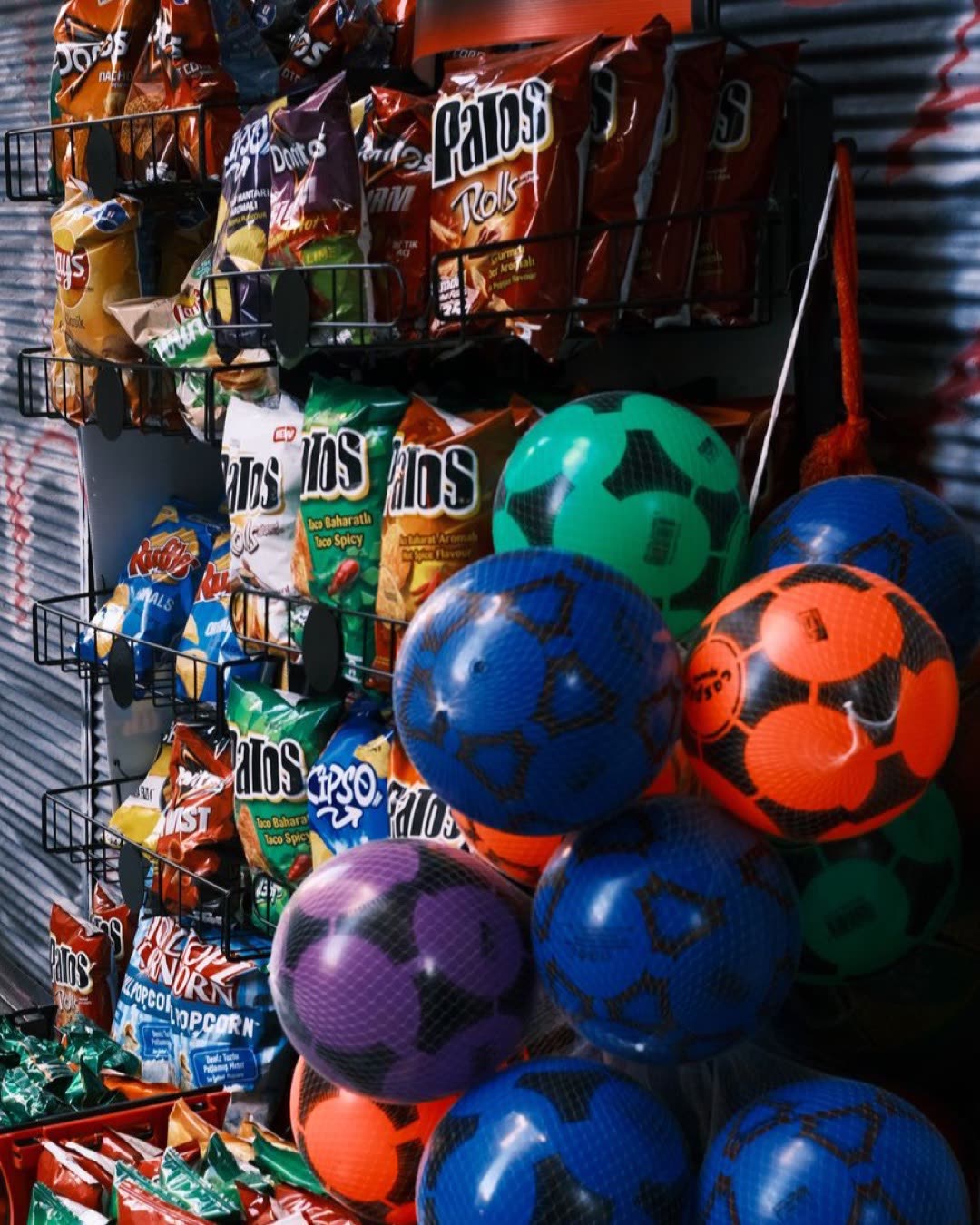 Vibrant assortment of snack foods and colorful balls in a store setting. Bold colors and diverse product selection.