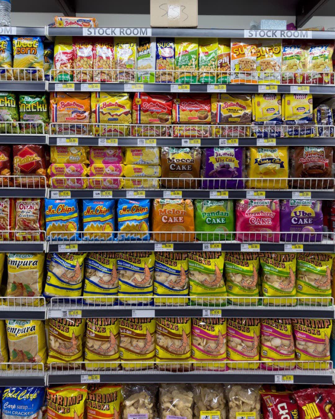 Variety of snacks in an indoor supermarket aisle, colorful packaging.