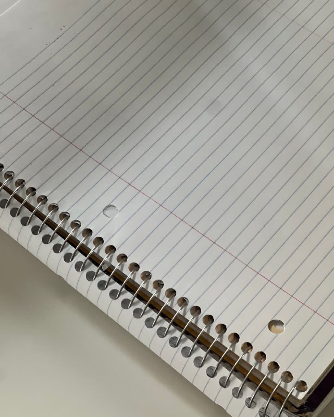 Close-up of a spiral-bound notebook showing its lined pages, perfect for writing or education purposes.