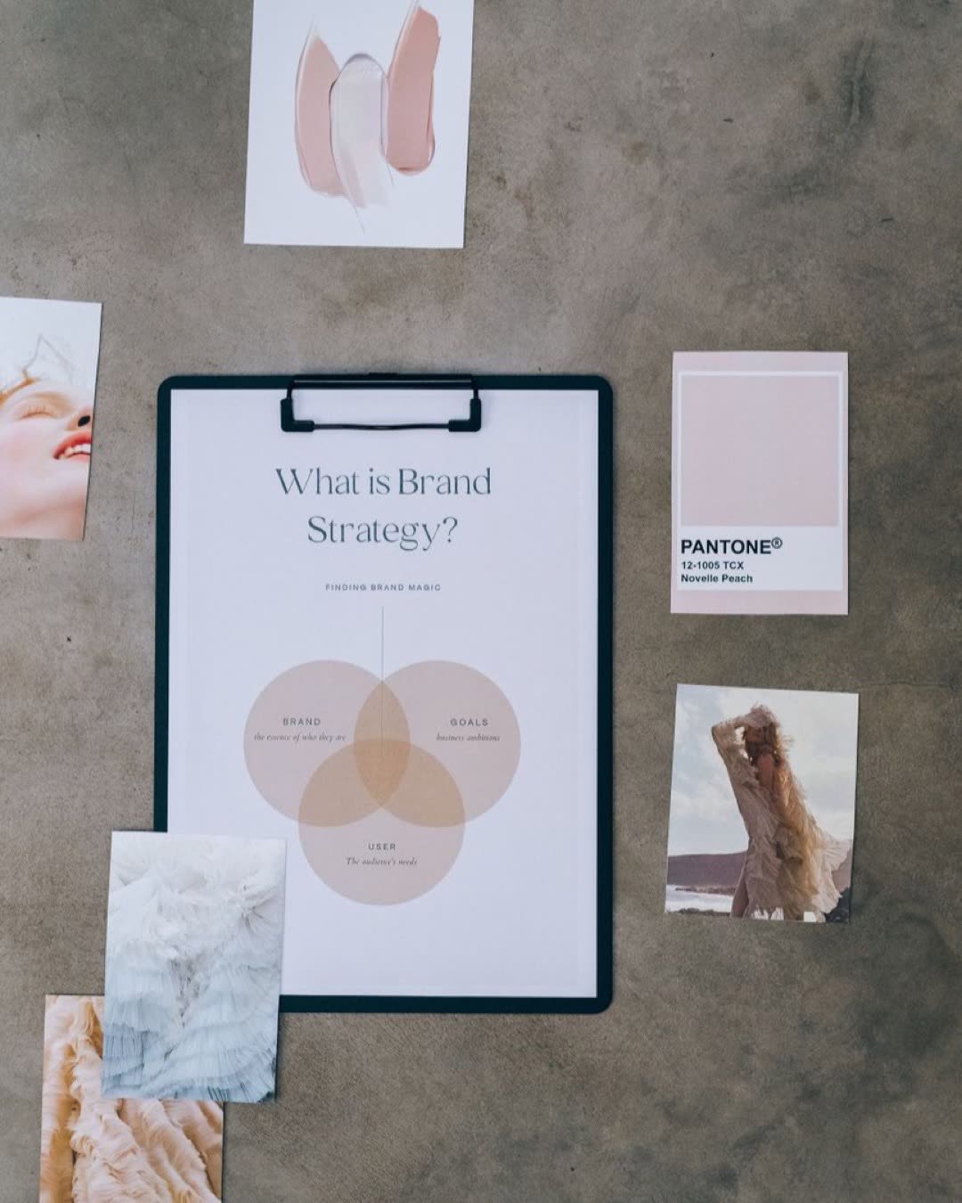 Flat lay of a brand strategy board surrounded by mood and color swatches on concrete.