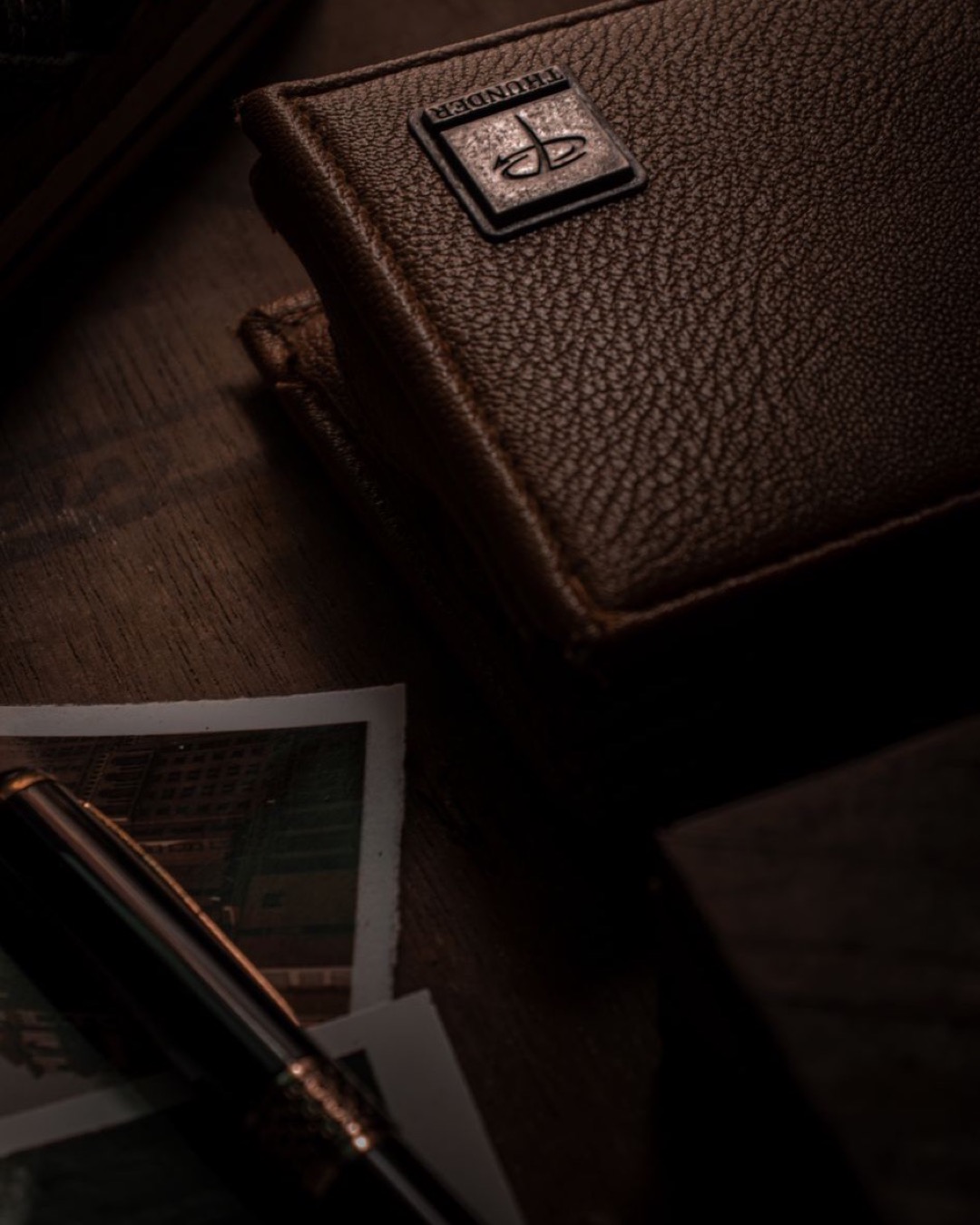 Stylish brown leather wallet with embossed texture and metallic emblem.
