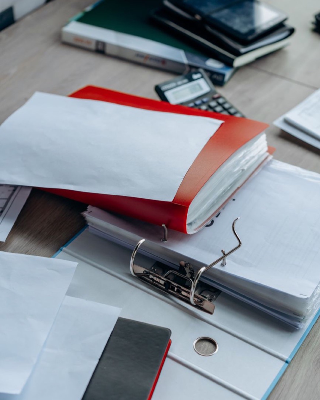 Tidy office desk with binders, papers, and stationery, ideal for business or education themes.