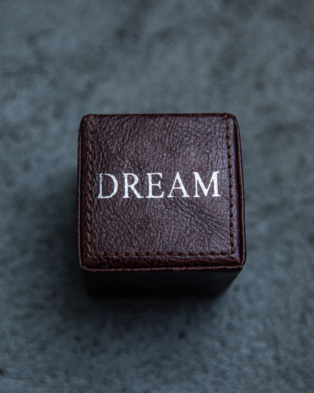 Close-up of a leather box featuring the word 'DREAM' embossed on it.