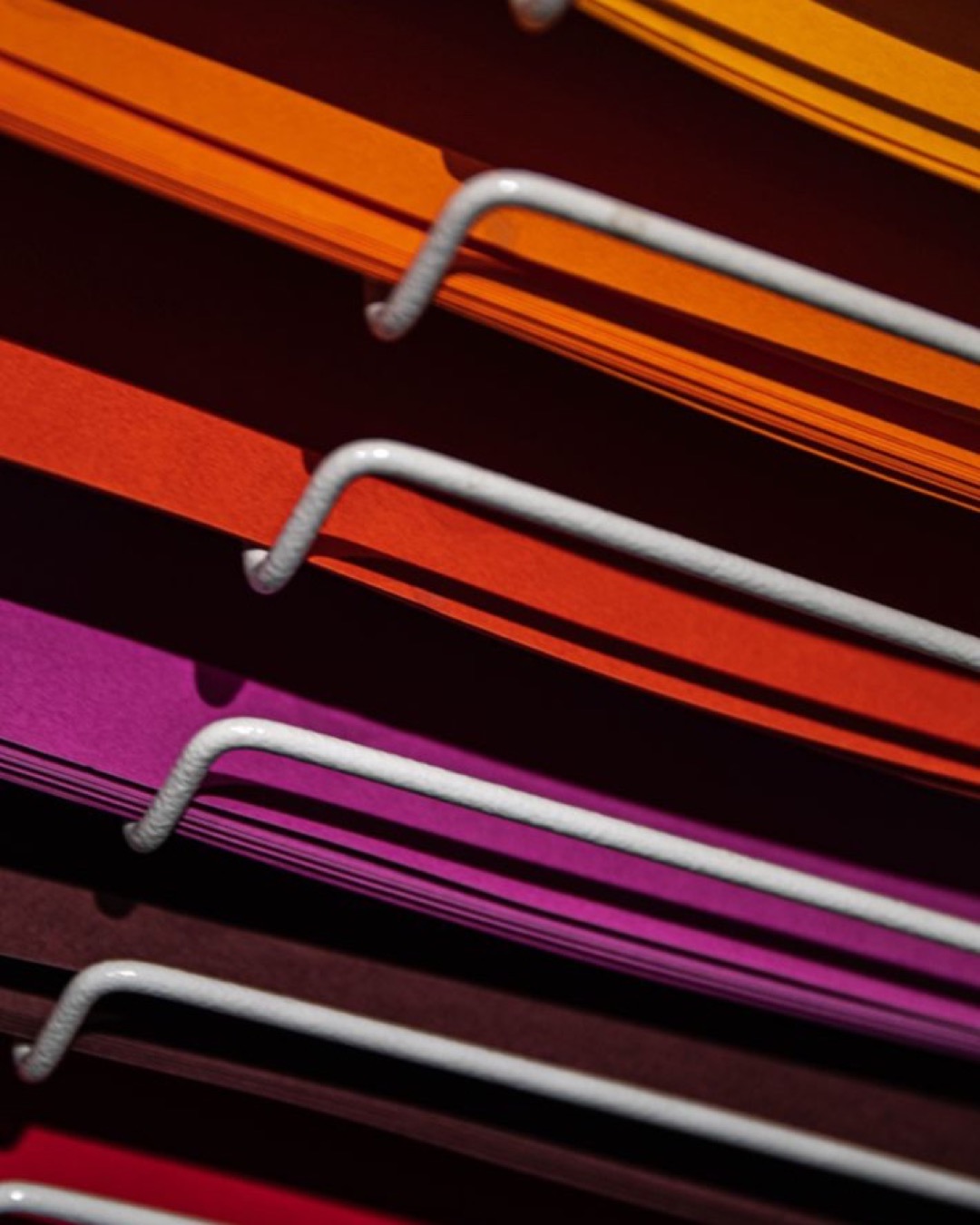 Close-up of stacked colored paper and metal bars with vibrant colors.