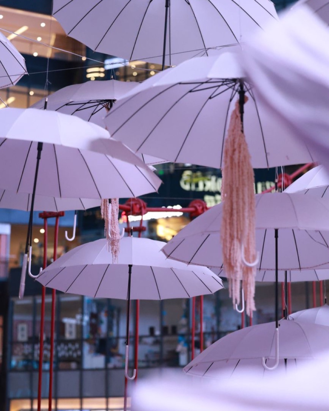 Creative installation of umbrellas hanging indoors in a vibrant mall setting.