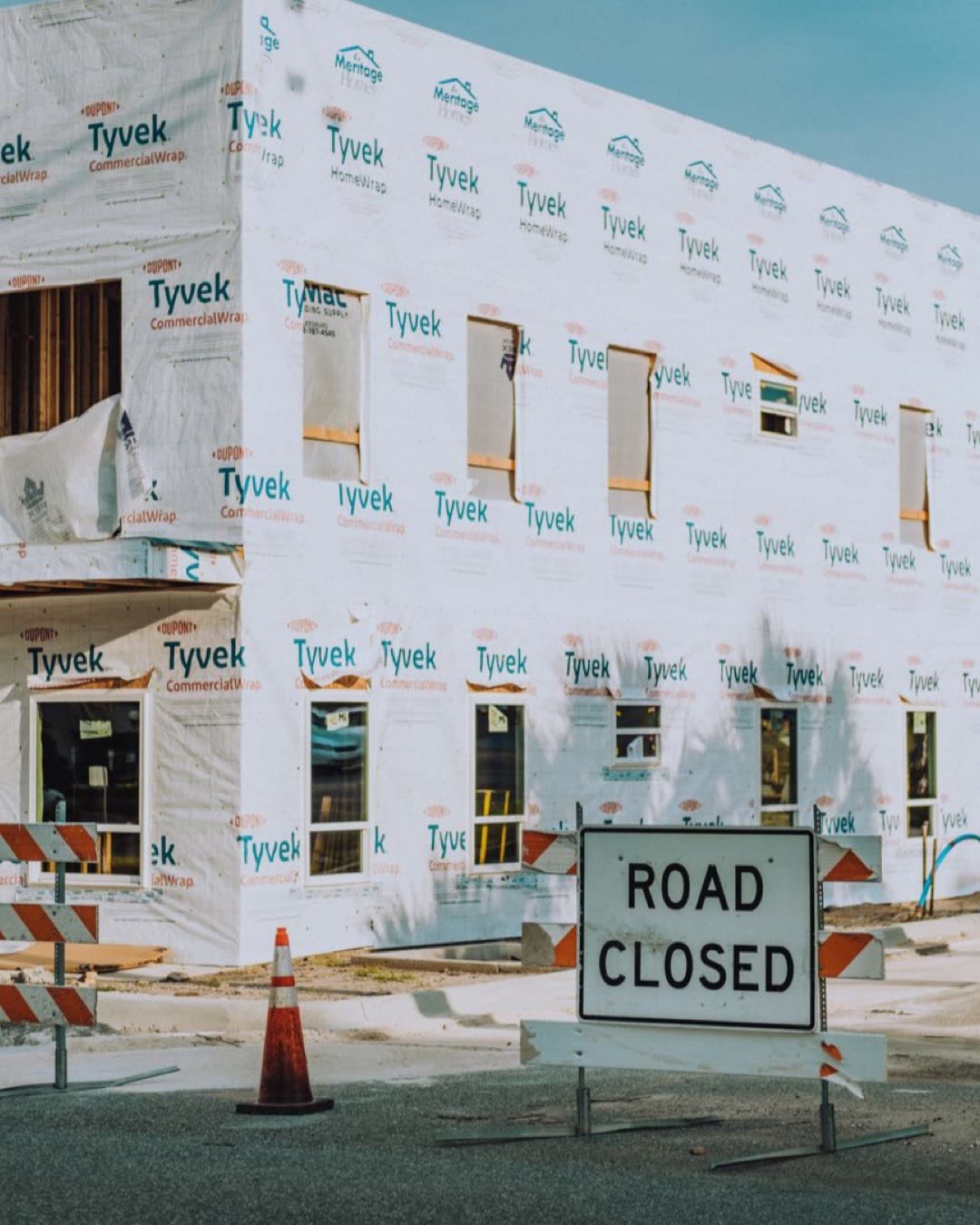 New building under construction with a road closed sign in the foreground.