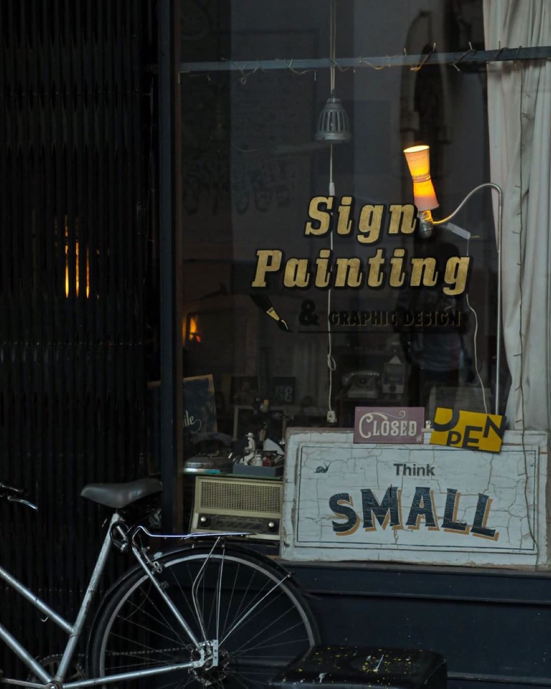 A quaint storefront featuring a bicycle and vintage sign designs.