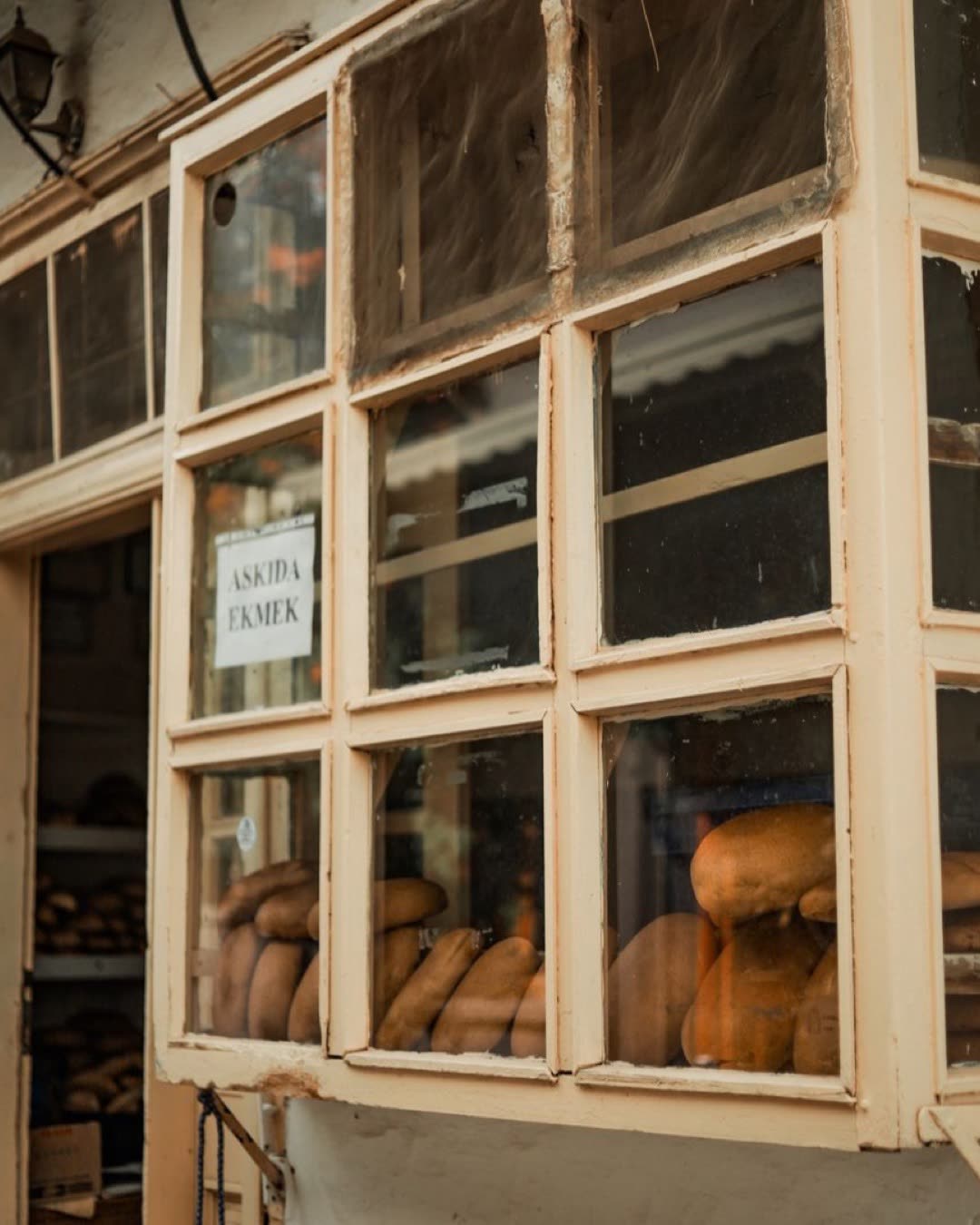 Exterior view of a bakery with fresh bread in window display.