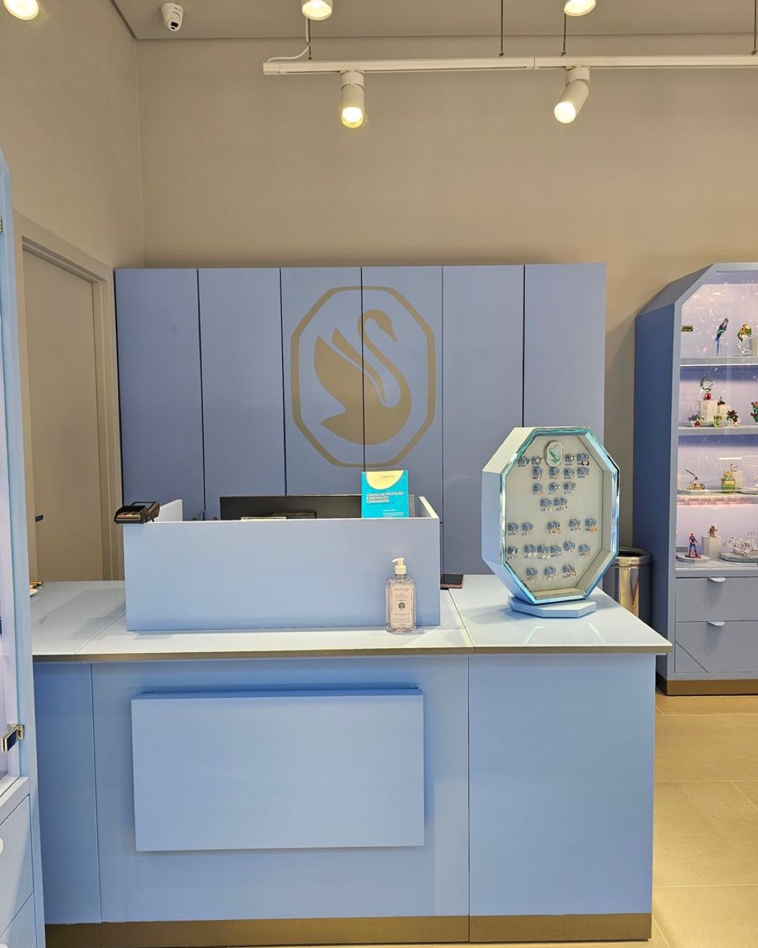 Modern jewelry store interior with iconic swan logo and vibrant blue decor, ideal for fashion and retail themes.