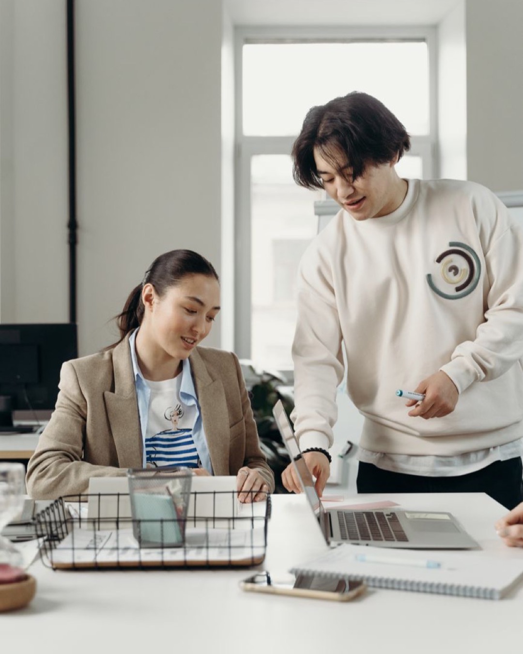 Diverse professionals engage in teamwork and project planning in a bright modern office setting.