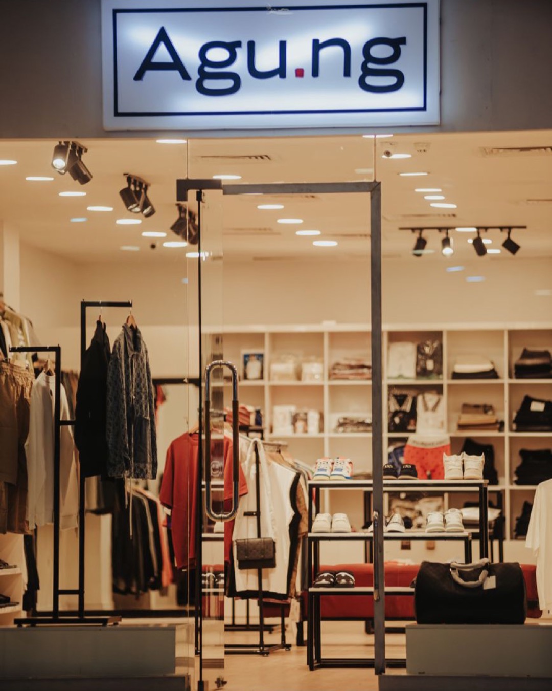 Stylish clothing store with modern design, displaying apparel and accessories under warm lighting.
