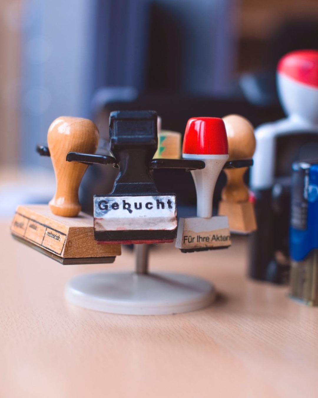 A detailed close-up of various rubber stamps on a stand in an office setting.