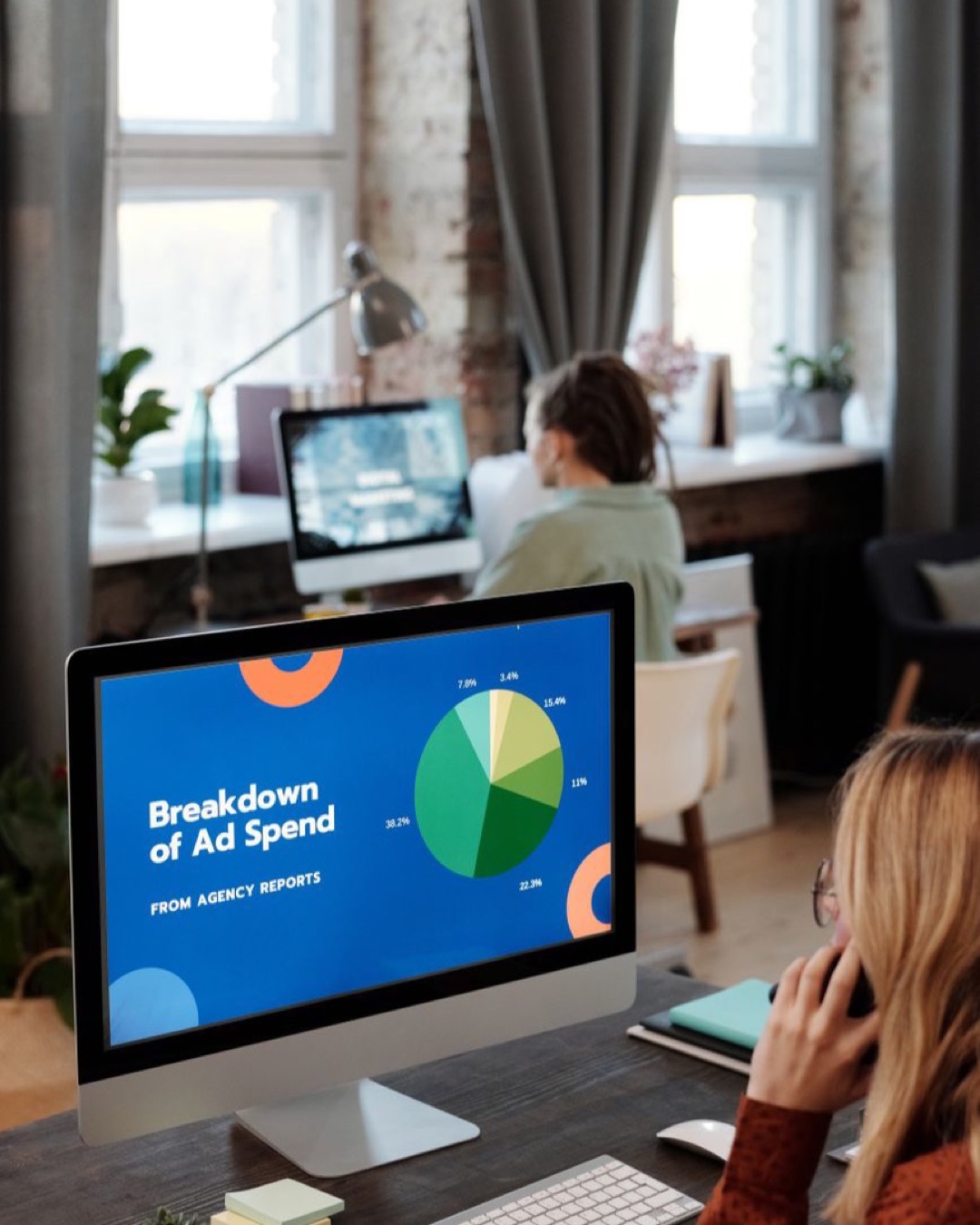 Bright office setting with computers displaying data, illustrating productivity in a workspace.